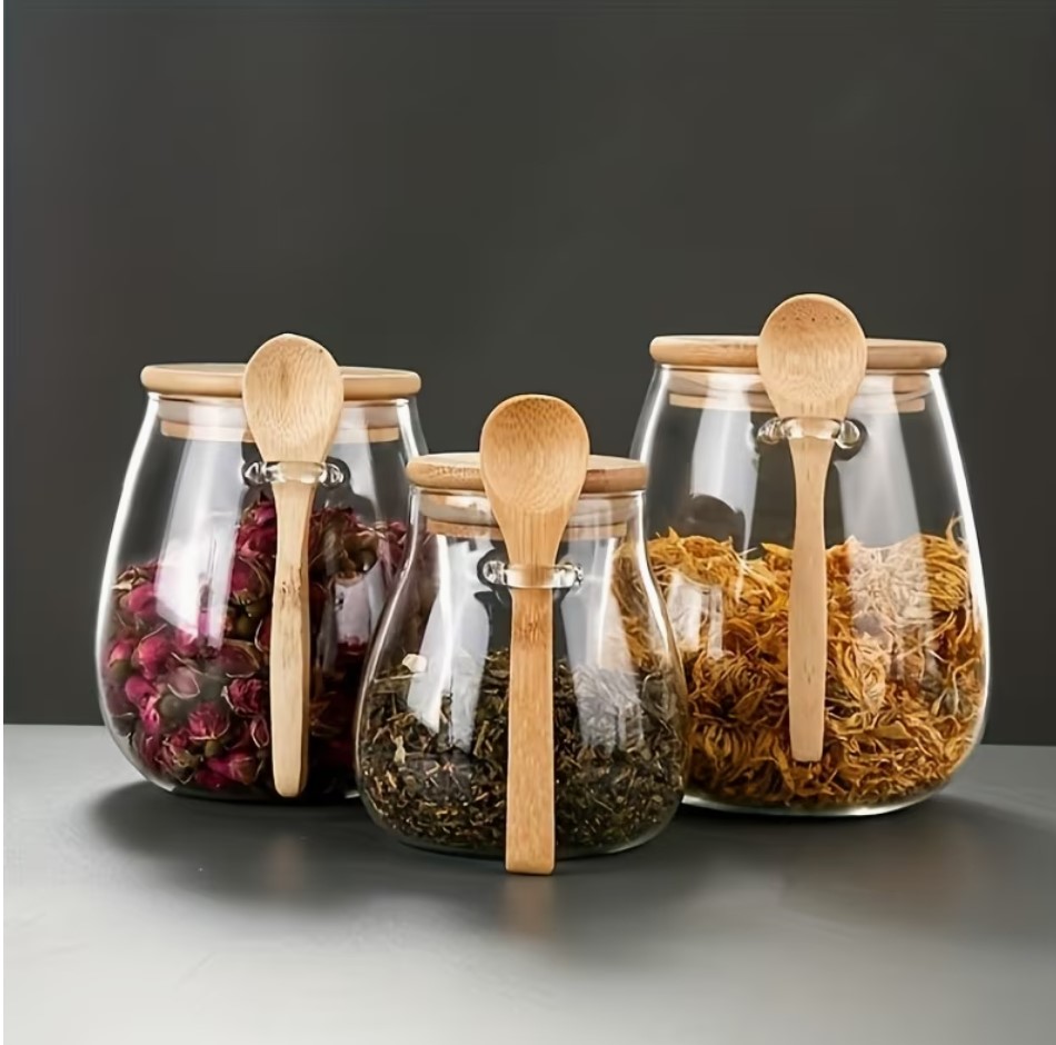 Glass spice jars with bamboo lids and wooden spoons