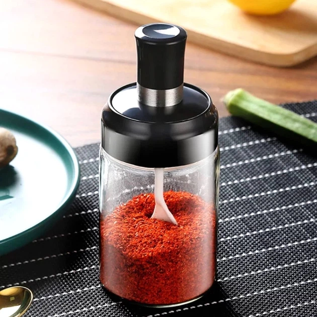 Glass spice jar with integrated measuring spoon dispenser